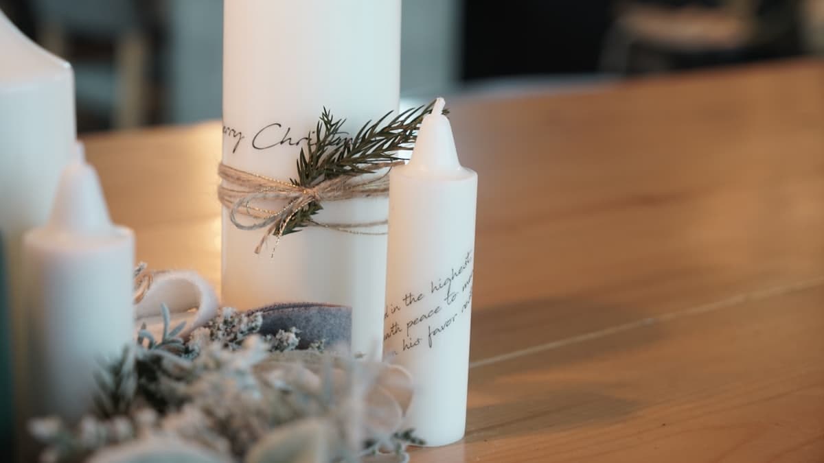 Velas blancas encendidas sobre una mesa decorada para un bautizo