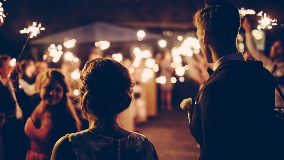 Novios entrando entre invitados que sostienen estrellitas encendidas
