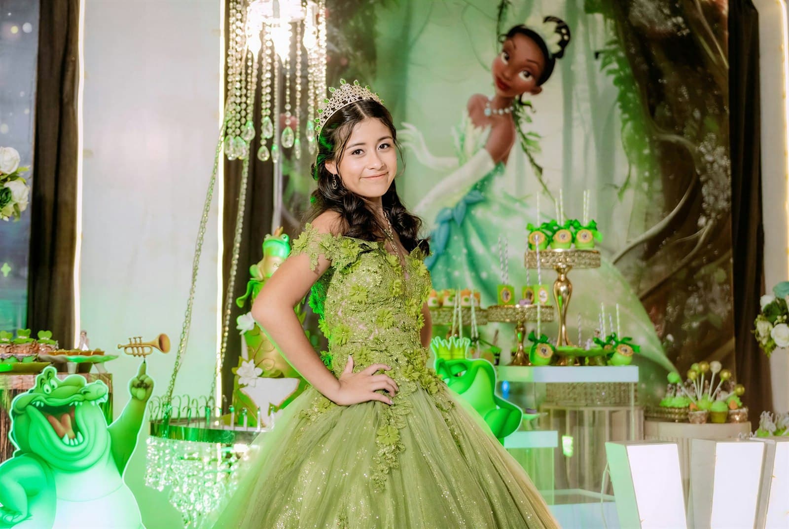 Quinceañera con vestido verde y corona en su fiesta