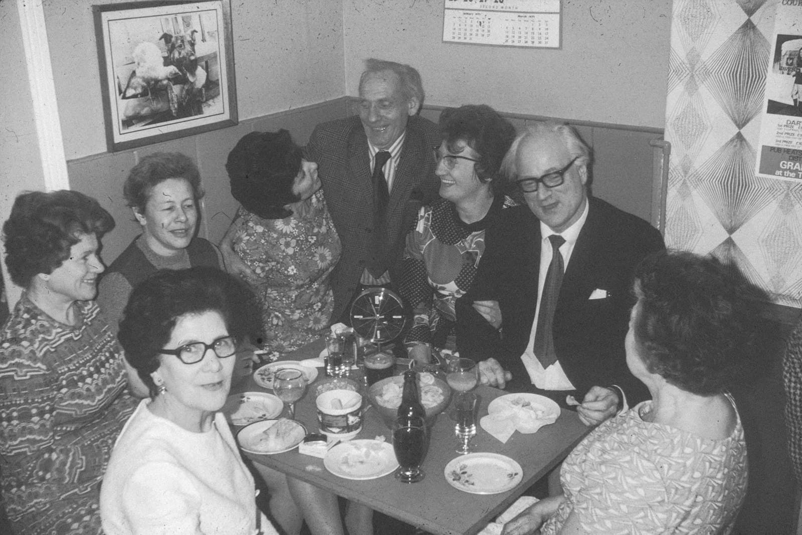 Grupo de invitados reunidos alrededor de una mesa larga