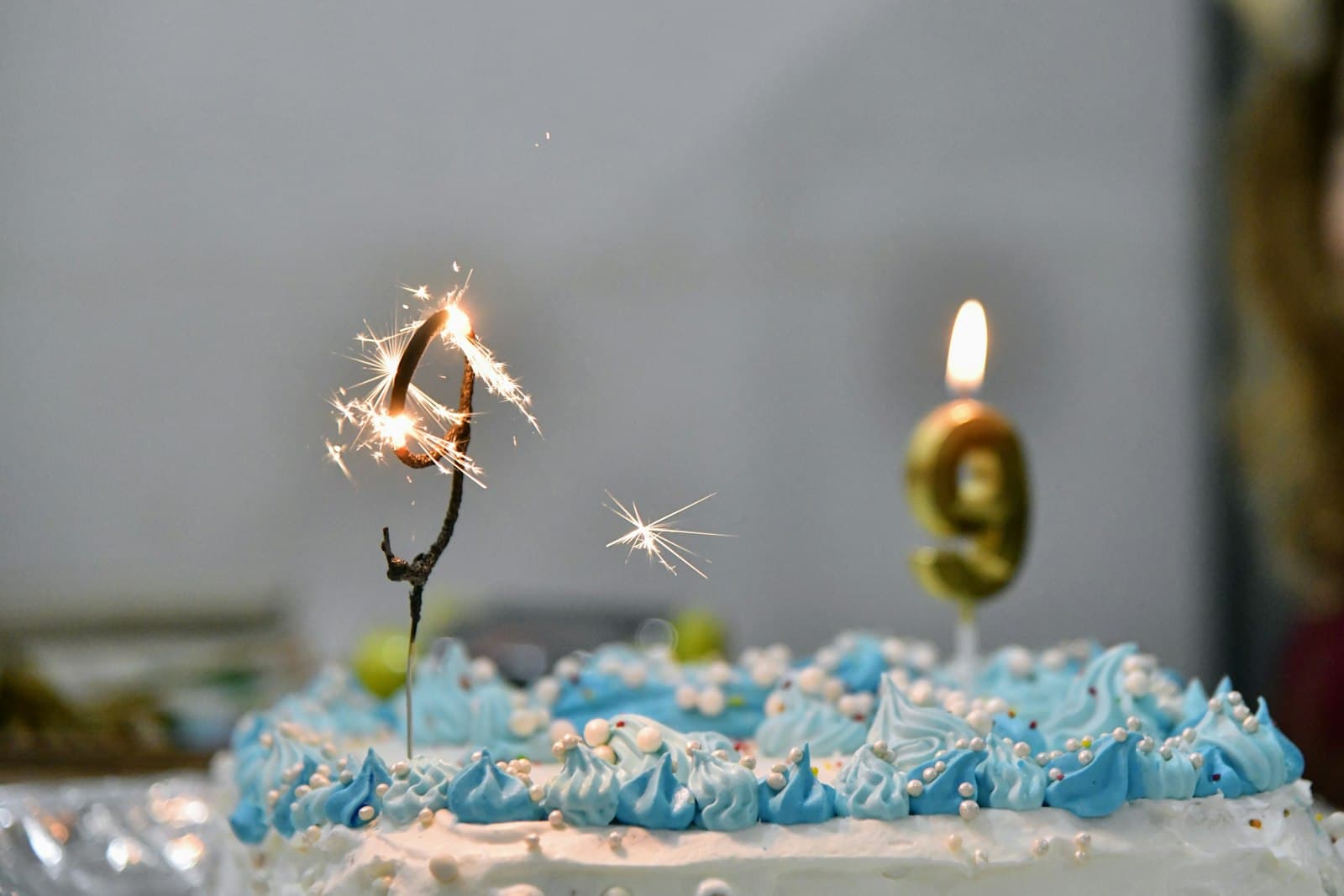 Torta de cumpleaños con una bengala encendida sobre una mesa