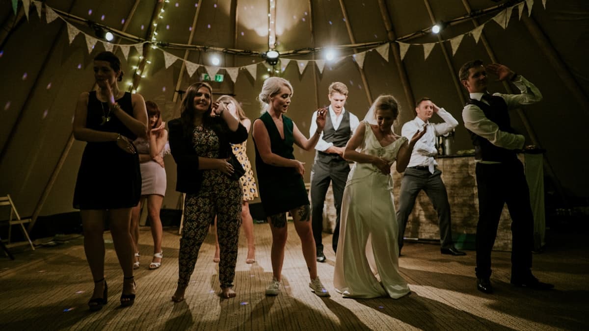 Invitados bailando y riéndose en la fiesta de un casamiento