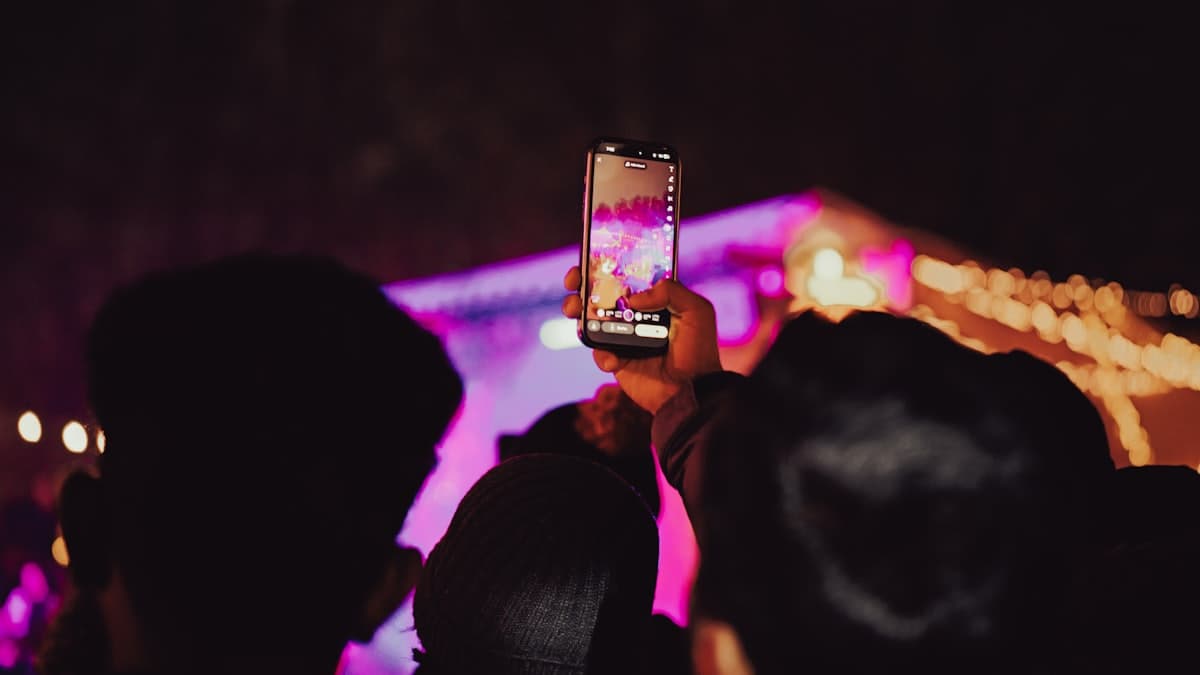 Persona sacando una foto con el celular en una fiesta de noche
